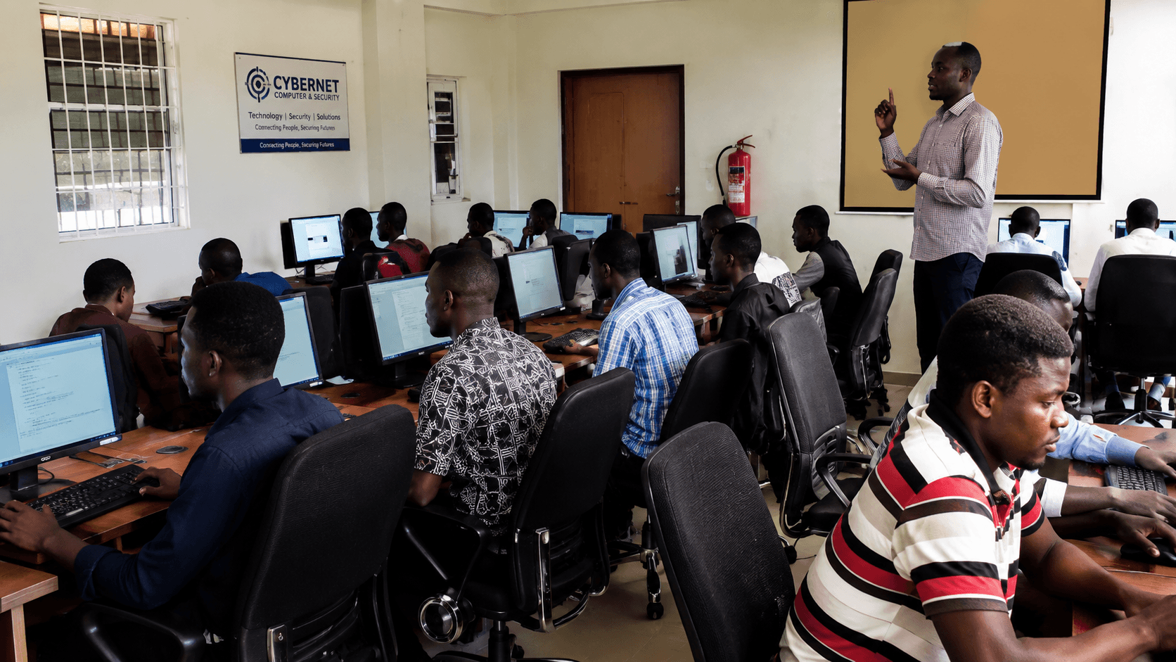 Cybernet instructor conducting hands-on digital health systems training for clinical workers in a dedicated computer laboratory