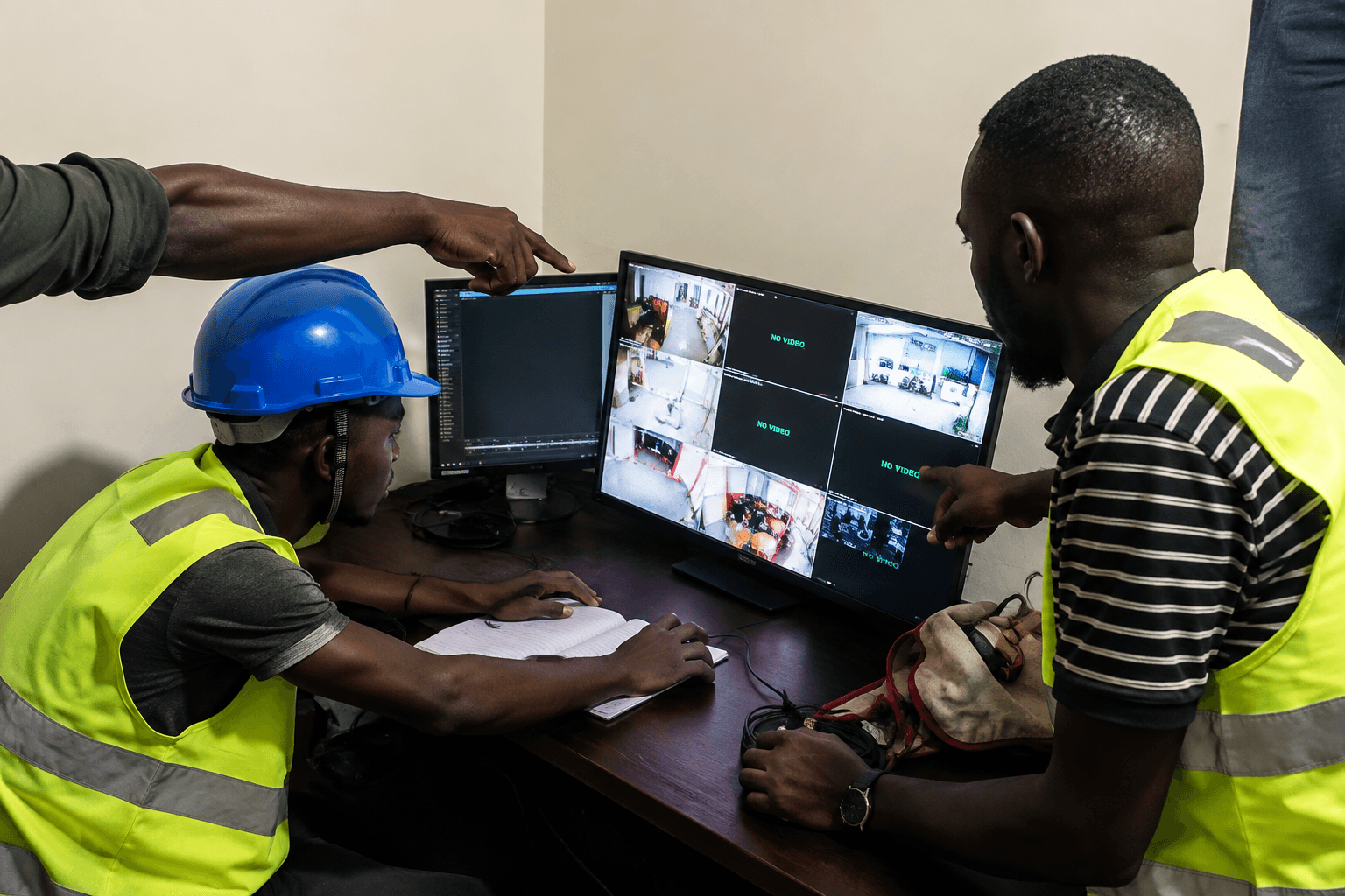 Cybernet security engineers reviewing multi-channel IP security camera streams and attendance terminal telemetry for Redeem International